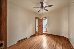 Empty room featuring light wood finished floors, baseboards, and a ceiling fan