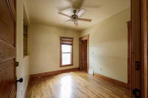 Unfurnished room with a ceiling fan, baseboards, and light wood-type flooring