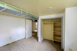Unfurnished bedroom with carpet flooring, a closet, and baseboards