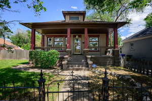 View of front of house with a porch, a fenced front yard, and a gate