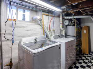 Below grade area featuring tile patterned floors, independent washer and dryer, and gas water heater