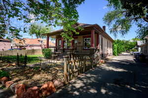 View of front facade featuring a porch, a fenced front yard, and a chimney