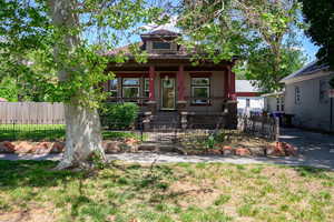 View of front of home with covered porch and a fenced front yard