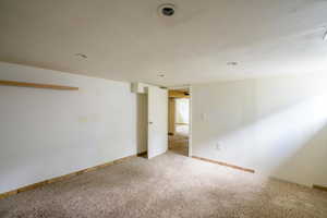 Carpeted spare room featuring baseboards