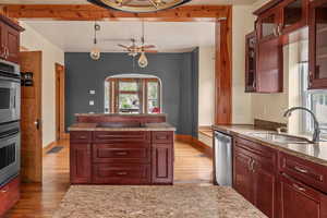 Kitchen featuring a sink, light wood-type flooring, appliances with stainless steel finishes, and baseboards