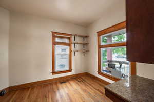Unfurnished dining area featuring baseboards and hardwood / wood-style flooring