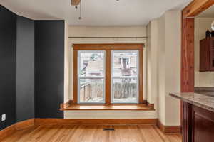Unfurnished dining area with light wood finished floors and baseboards