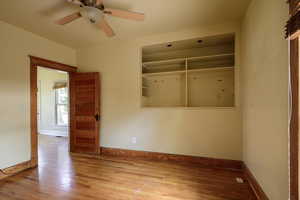 Unfurnished bedroom featuring baseboards, wood finished floors, and ceiling fan