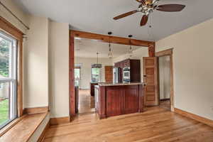 Kitchen with appliances with stainless steel finishes, baseboards, and light wood finished floors