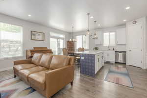 Living room featuring wood finished floors, recessed lighting, baseboards, and a chandelier