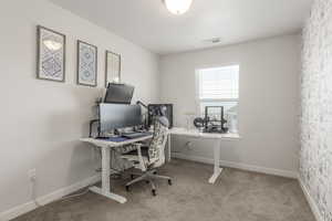 Carpeted home office featuring baseboards