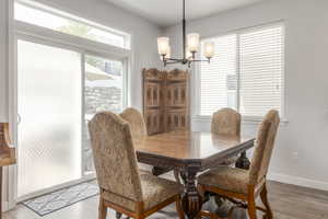 Dining space with a chandelier, light wood-style flooring, and baseboards