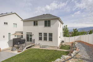 Rear view of property featuring a deck with mountain view, stucco siding, a gate, and roof with shingles