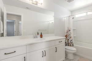 Full bath with toilet, vanity, shower / bath combo, and tile patterned flooring
