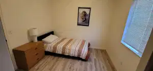Main unit-Bedroom with light wood finished floors and baseboards