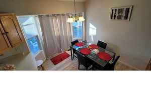 Main unit-Dining room with a chandelier, light wood-style floors, and baseboards