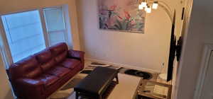Main unit-Living area with a chandelier and baseboards