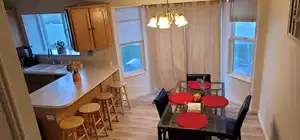 Main unit-Kitchen and Dining area featuring a chandelier, light wood finished floors, healthy amount of natural light, and baseboards