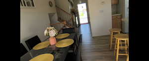 Main unit-Dining space with wood finished floors, stairs, and baseboards
