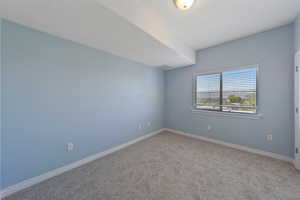 Carpeted empty room featuring baseboards