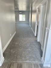 Hall with baseboards, carpet floors, and a textured ceiling