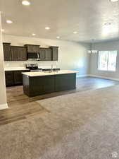 Kitchen with appliances with stainless steel finishes, a sink, a chandelier, light countertops, and recessed lighting