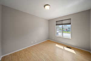 Unfurnished room featuring wood finished floors and baseboards