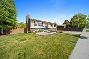 Bi-level home with a chimney and brick siding