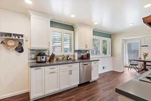 Remodeled kitchen featuring dishwasher, a sink, Quartz countertops, dark wood-style floors, and white cabinets