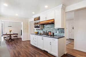 Remodeled  kitchen with stainless steel appliances with original 1956 (retro-fitted) gas range, white Shaker-style cabinetry, Quartz counters, tasteful marble tile backsplash, under cabinet range hood, and recessed lighting