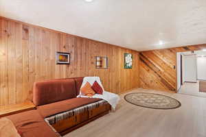 Finished basement family room area featuring LVP  flooring and decorative wood slat walls