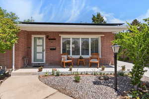 Entrance to property featuring a porch and brick siding