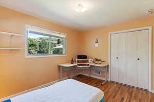 Bedroom with wood finished floors, a closet