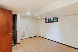 Below grade area featuring light wood-style flooring, baseboards, and recessed lighting