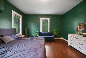 Bedroom featuring dark wood finished floors and baseboards