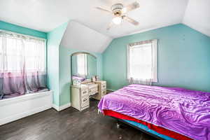 Bedroom with vaulted ceiling, wood finished floors, a ceiling fan, and baseboards