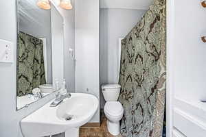 Bathroom with toilet, a sink, and tile patterned flooring