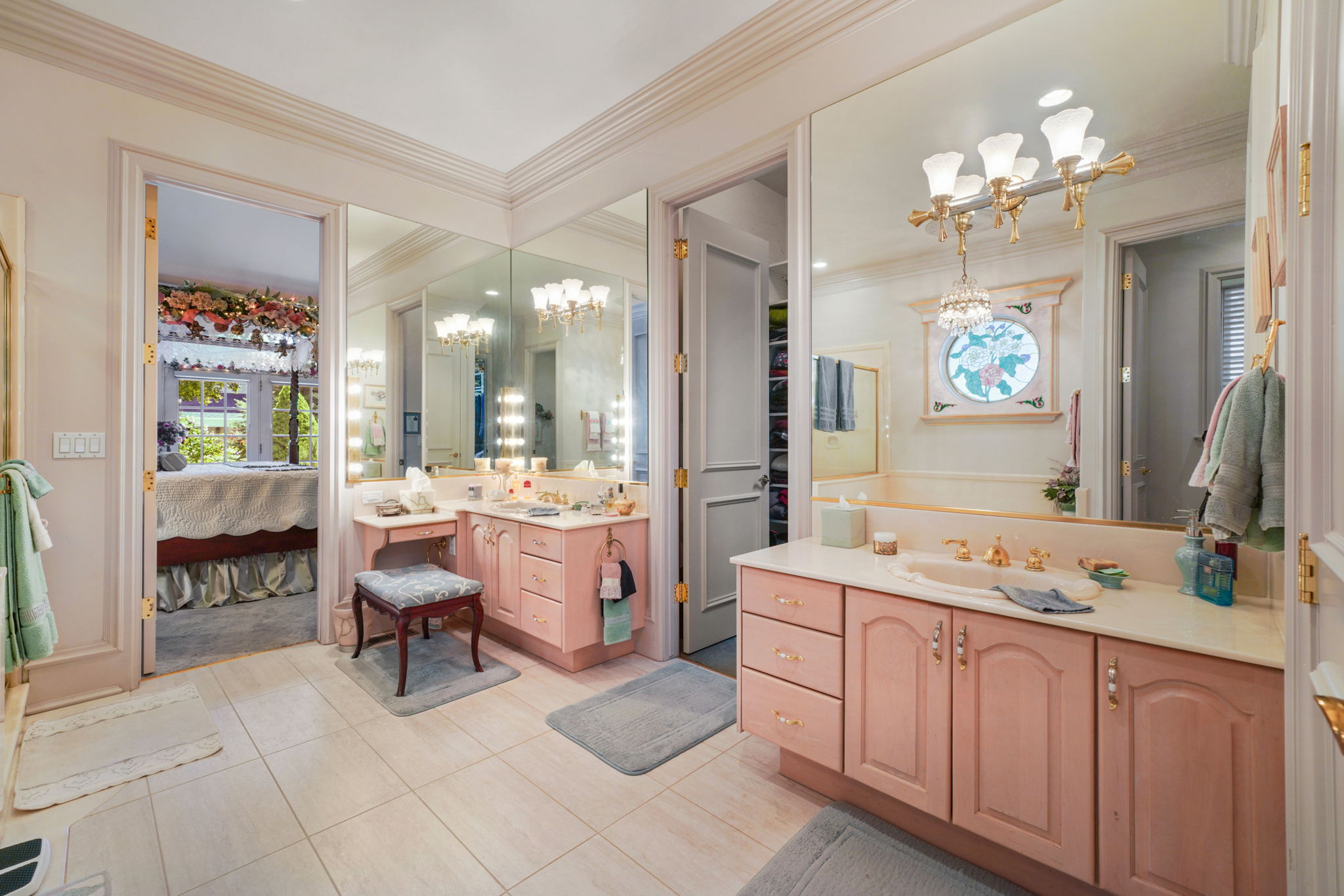 Ensuite bathroom featuring a chandelier, tile patterned floors, two vanities, and ornamental molding