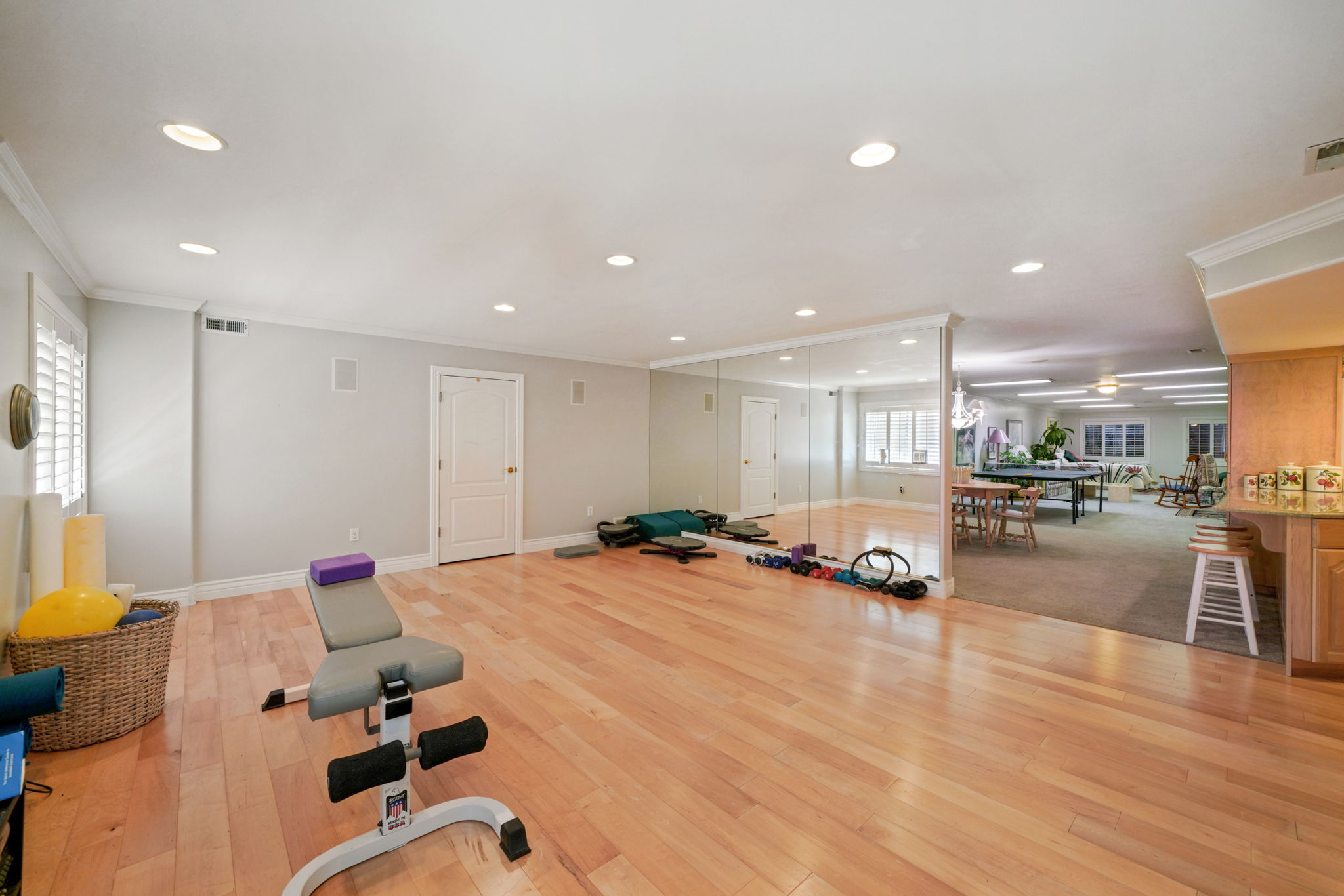 Exercise room featuring ornamental molding, recessed lighting, and light wood-style flooring