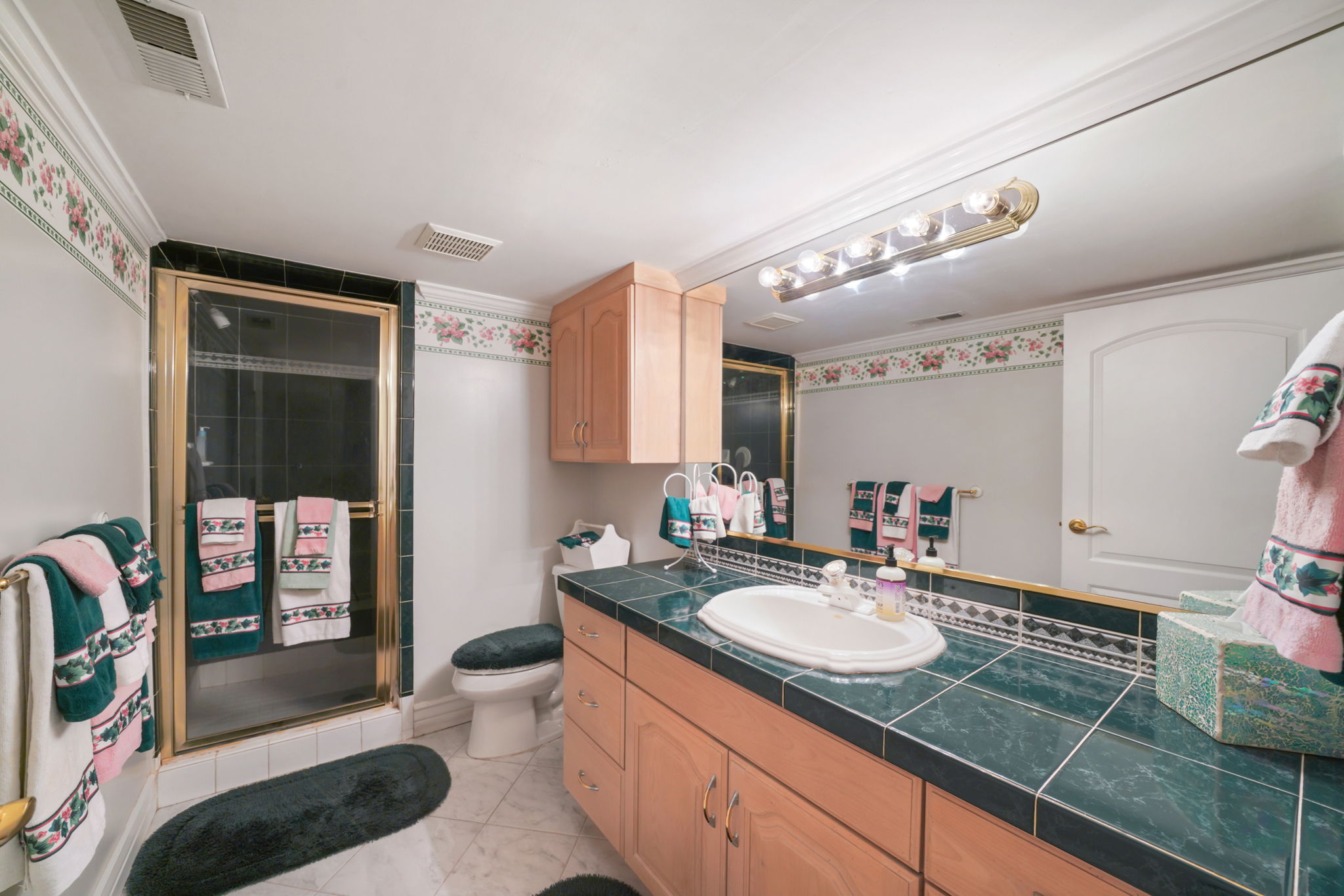 Bathroom with vanity, a stall shower, and ornamental molding