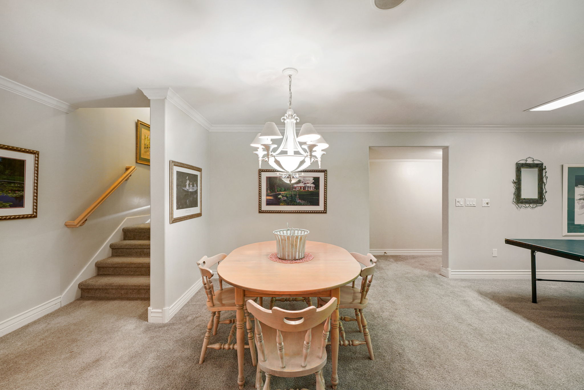 Dining room with carpet, a chandelier, stairs, and ornamental molding
