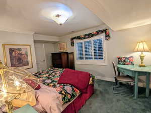 Carpeted bedroom with ornamental molding and baseboards