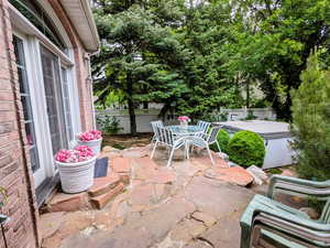Fenced backyard featuring a patio area, outdoor dining area, and a hot tub