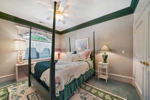 Bedroom with carpet floors, crown molding, and a ceiling fan