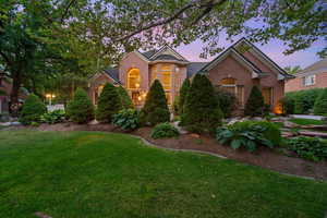 Traditional-style house featuring brick siding and a yard