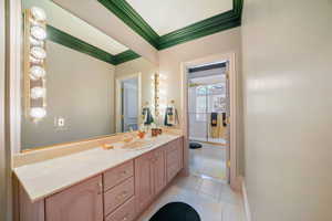Bathroom featuring crown molding, tile patterned floors, and vanity