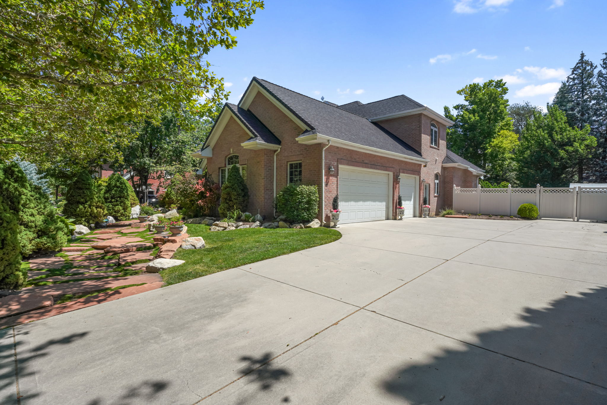 View of side of home featuring brick siding, driveway, a garage, and a shingled roof