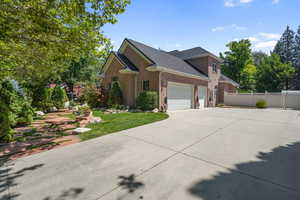 View of side of home featuring brick siding, driveway, a garage, and a shingled roof
