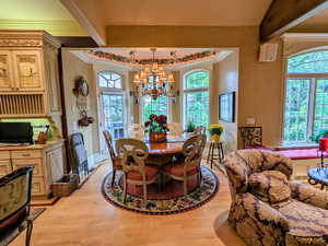 Dining space featuring a chandelier, ornamental molding, light wood finished floors, and baseboards