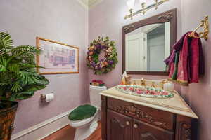 Bathroom with vanity, wood finished floors, and crown molding